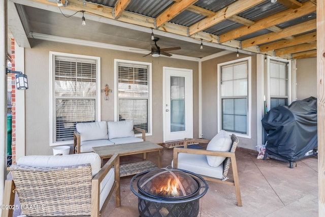 view of patio with a ceiling fan, an outdoor living space with a fire pit, and area for grilling