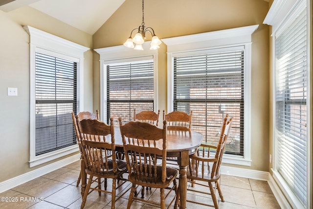 dining space with light tile patterned floors, vaulted ceiling, baseboards, and a notable chandelier