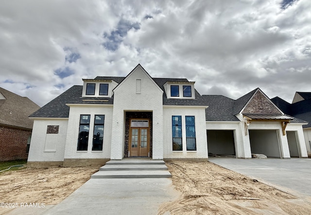 view of front facade featuring a garage, brick siding, concrete driveway, french doors, and roof with shingles