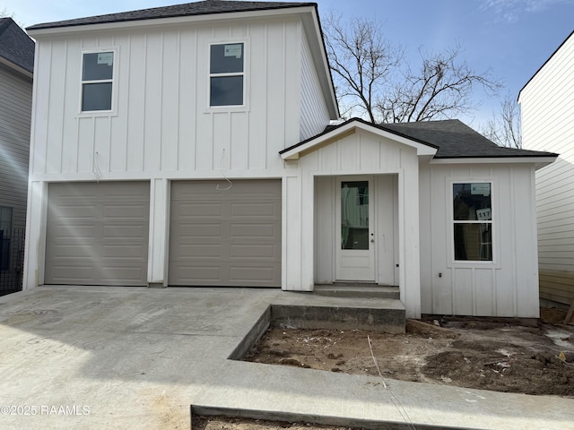 modern farmhouse featuring board and batten siding, a shingled roof, driveway, and a garage