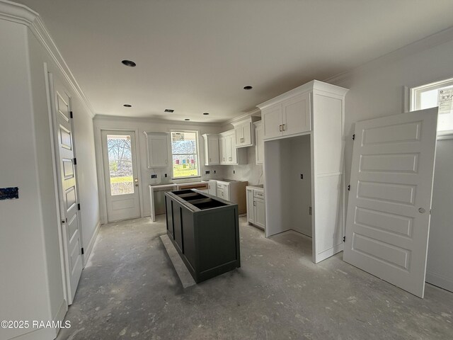 kitchen featuring ornamental molding, a center island, and white cabinetry