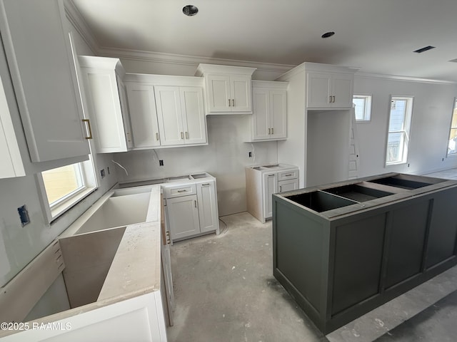 kitchen with visible vents, ornamental molding, a kitchen island, white cabinets, and concrete flooring