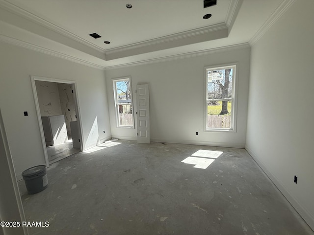 empty room with baseboards, a raised ceiling, and crown molding