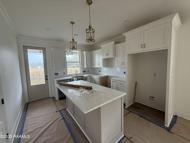 kitchen featuring visible vents, a sink, dishwasher, backsplash, and a center island