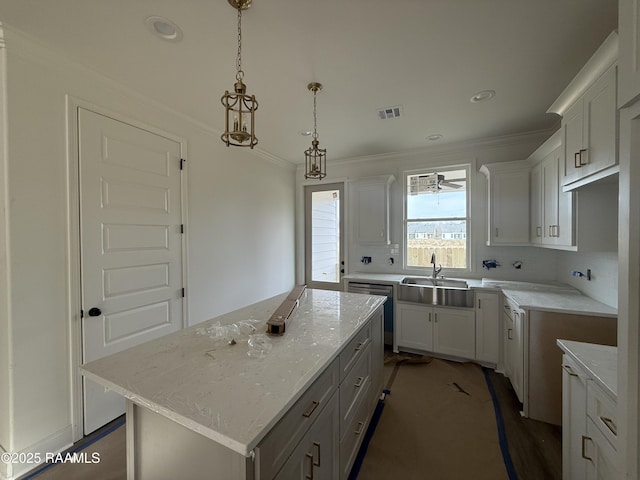 kitchen with light stone countertops, visible vents, a kitchen island, white cabinetry, and crown molding