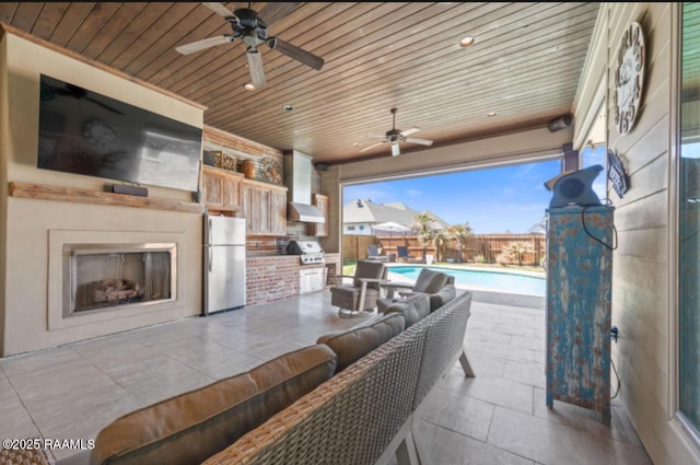 view of patio with fence, exterior kitchen, grilling area, a fenced in pool, and an outdoor living space with a fireplace