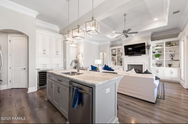 kitchen featuring arched walkways, a fireplace, dark wood-type flooring, a sink, and dishwasher