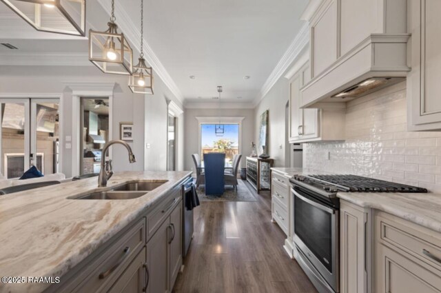 kitchen featuring appliances with stainless steel finishes, dark wood-style flooring, hanging light fixtures, light stone countertops, and a sink