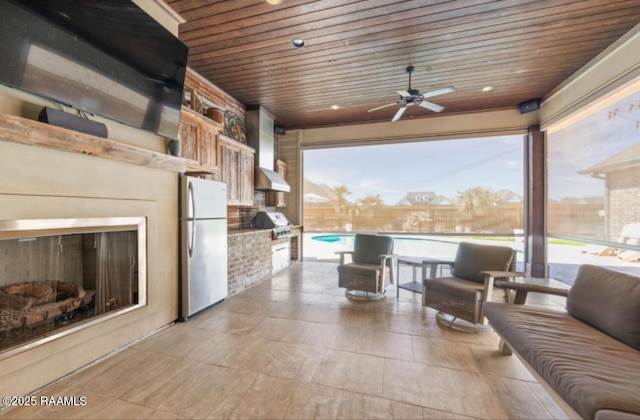 view of patio / terrace with a fenced in pool, area for grilling, ceiling fan, and an outdoor kitchen