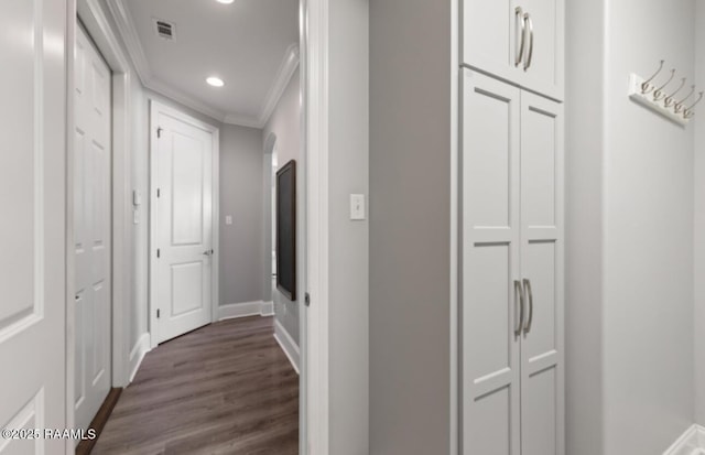 corridor featuring baseboards, visible vents, dark wood-type flooring, crown molding, and recessed lighting