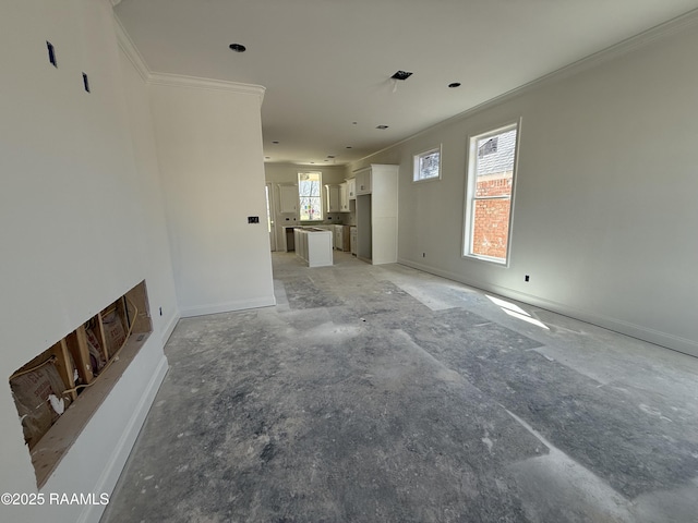 unfurnished living room with baseboards and ornamental molding