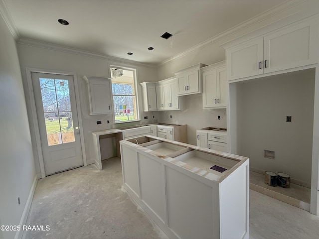 kitchen with baseboards, a kitchen island, ornamental molding, and white cabinetry