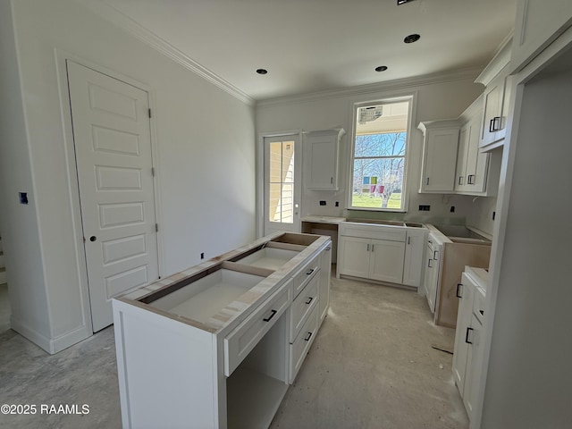 kitchen with white cabinetry, a kitchen island, and crown molding