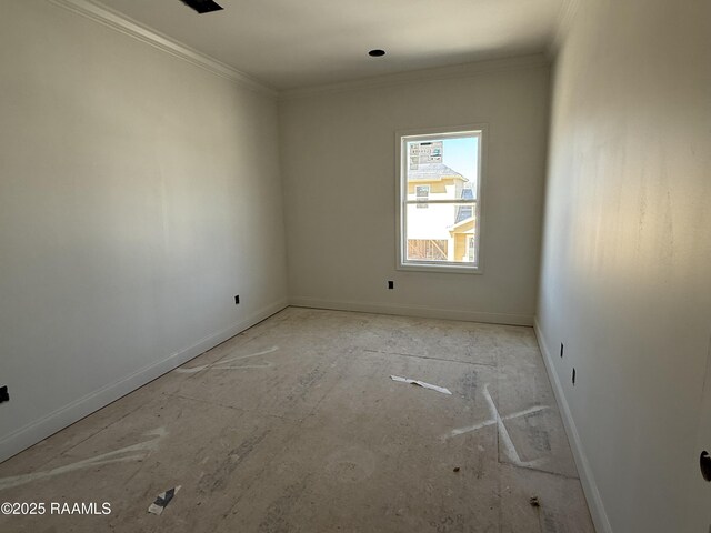 empty room featuring crown molding and baseboards