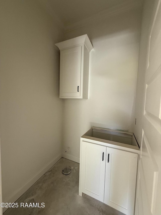 laundry room featuring baseboards and crown molding