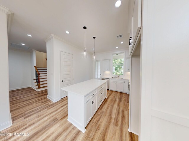 119 Chimney Rock Blvd, Lafayette, LA 70508 - kitchen with dishwasher, light wood-type flooring, white cabinets, light countertops, and recessed lighting