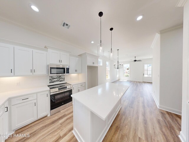 119 Chimney Rock Blvd, Lafayette, LA 70508 - kitchen with stainless steel appliances, crown molding, white cabinets, a ceiling fan, and backsplash