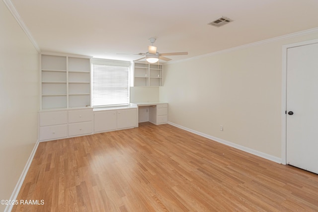 interior space with built in desk, visible vents, ornamental molding, light wood-style floors, and baseboards