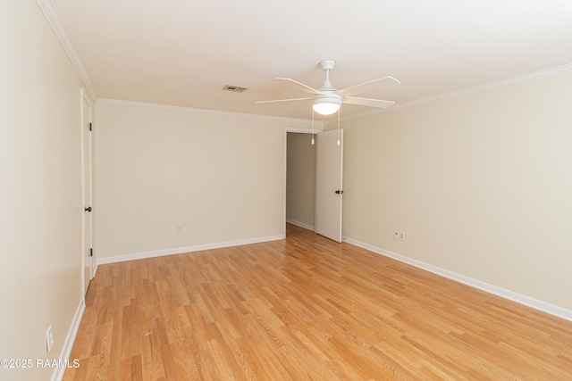 spare room featuring ornamental molding, light wood finished floors, visible vents, and baseboards