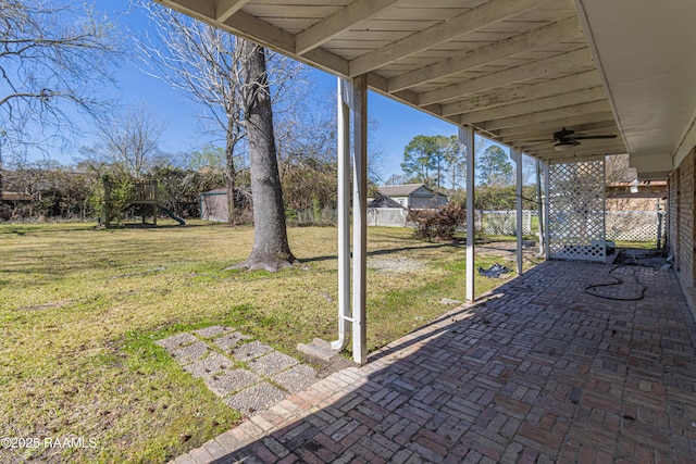 view of patio / terrace with a playground, fence, and ceiling fan