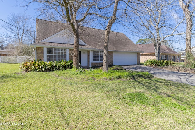 view of front of house with brick siding, an attached garage, fence, driveway, and a front lawn