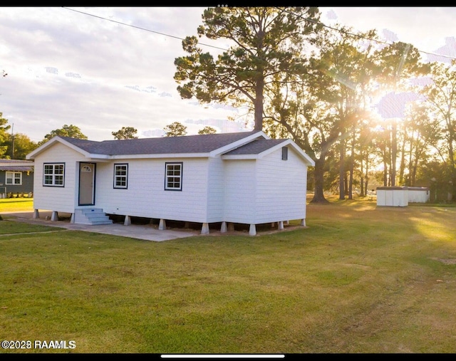 back of property featuring a lawn, roof with shingles, and entry steps