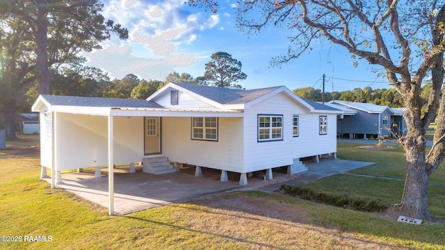 view of front of property with entry steps, a shingled roof, driveway, and a front lawn