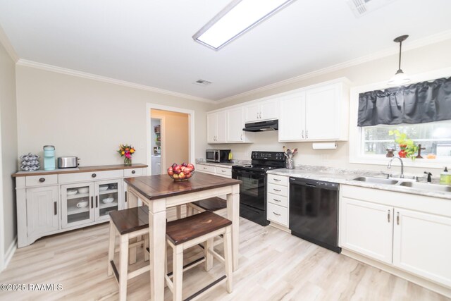 kitchen with black appliances, crown molding, under cabinet range hood, white cabinetry, and a sink