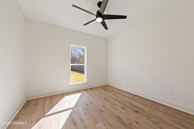 spare room featuring a ceiling fan, baseboards, and wood finished floors