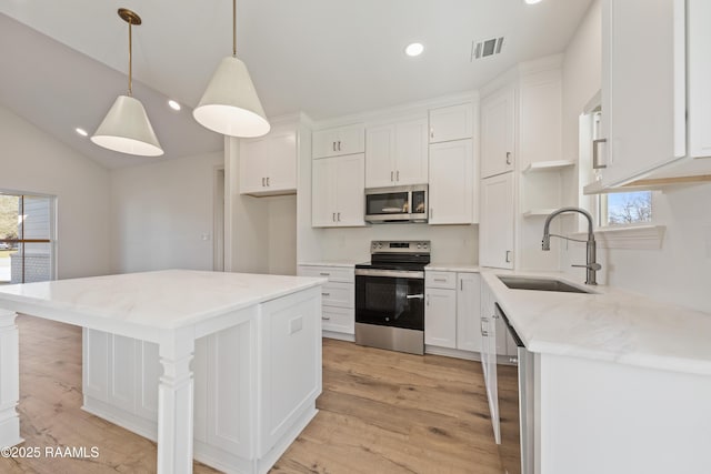 kitchen with appliances with stainless steel finishes, a sink, visible vents, and a healthy amount of sunlight