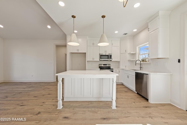 kitchen with light wood-style floors, white cabinetry, stainless steel appliances, and a sink