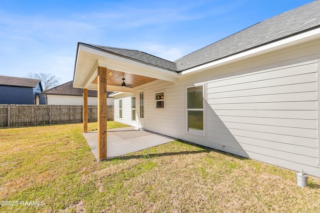 exterior space featuring a yard, a shingled roof, a patio area, fence, and ceiling fan