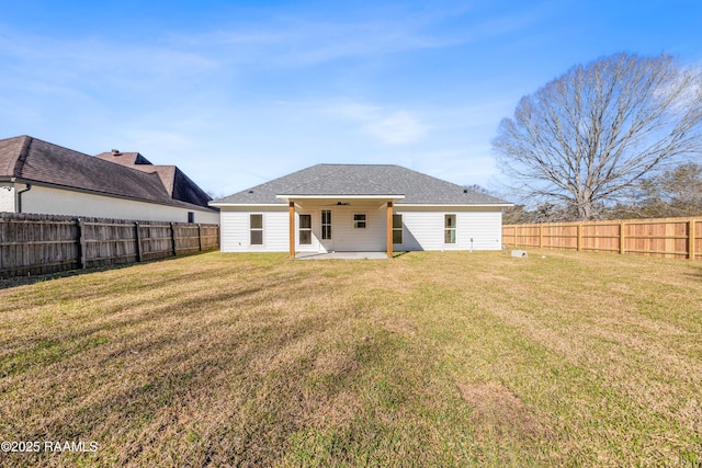 rear view of house with a patio, a fenced backyard, a shingled roof, a ceiling fan, and a lawn