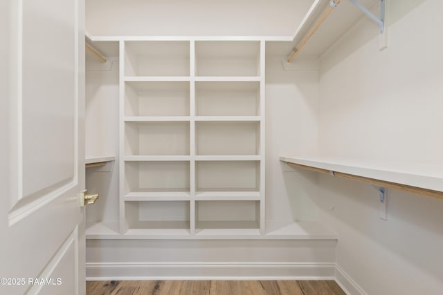 walk in closet with wood finished floors