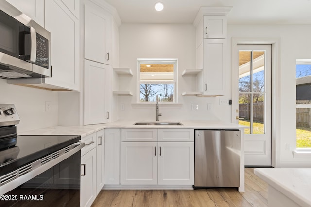 kitchen with white cabinetry, appliances with stainless steel finishes, open shelves, and a sink