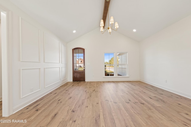 unfurnished dining area with baseboards, light wood-style flooring, vaulted ceiling with beams, a decorative wall, and a notable chandelier