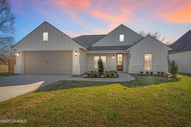 modern farmhouse featuring brick siding, a shingled roof, a yard, driveway, and board and batten siding