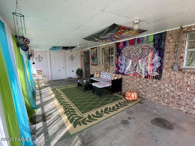 miscellaneous room featuring concrete floors and brick wall