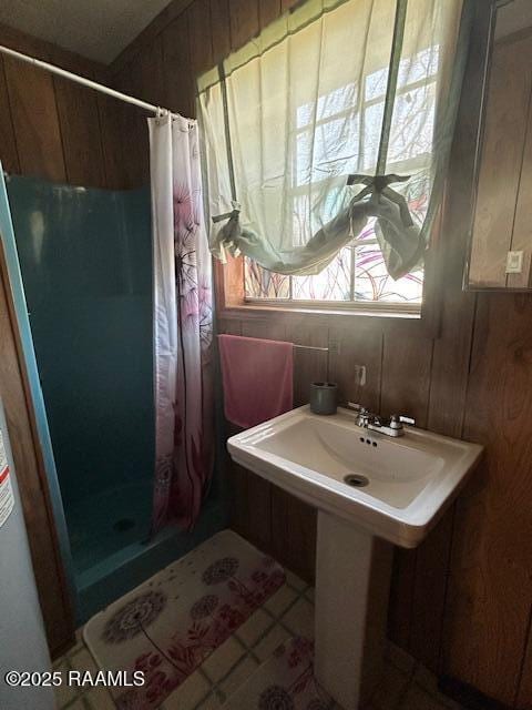 bathroom with a shower stall and tile patterned floors