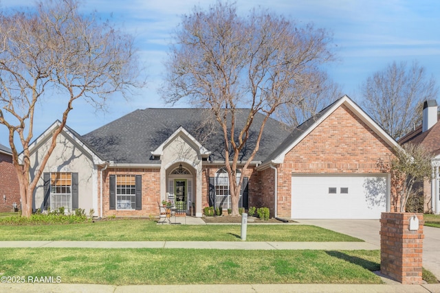 traditional-style home featuring roof with shingles, concrete driveway, a front yard, a garage, and brick siding