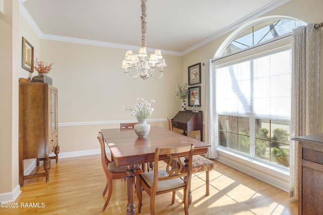 dining room with light wood-type flooring, plenty of natural light, a chandelier, and crown molding