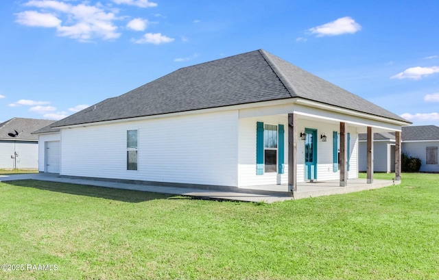 back of property with a yard and roof with shingles