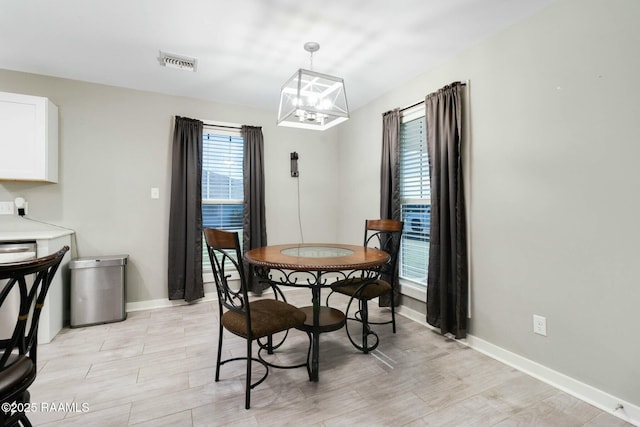 dining area with a chandelier, visible vents, and baseboards