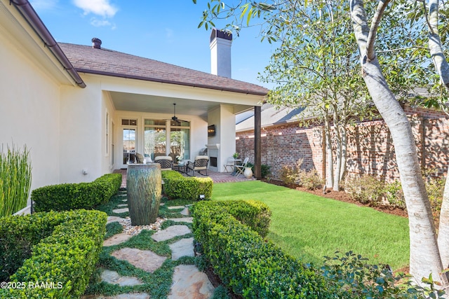 view of yard with ceiling fan and a patio