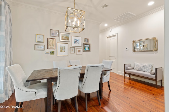 dining area featuring ornamental molding, wood finished floors, and visible vents