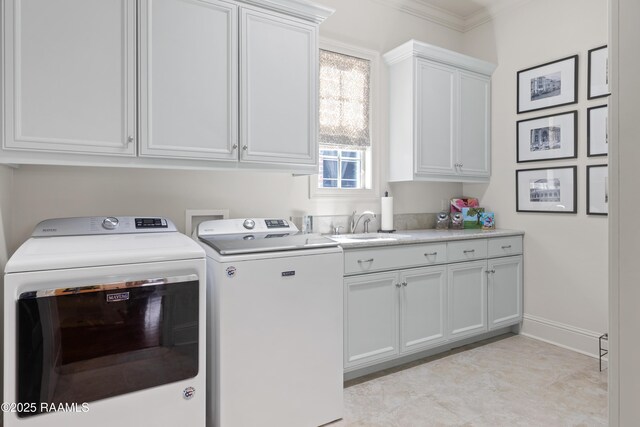 laundry area with washing machine and clothes dryer, cabinet space, ornamental molding, a sink, and baseboards