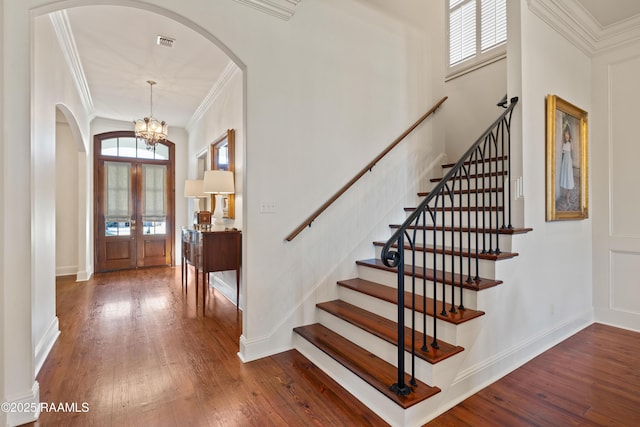 foyer entrance featuring visible vents, ornamental molding, and hardwood / wood-style floors