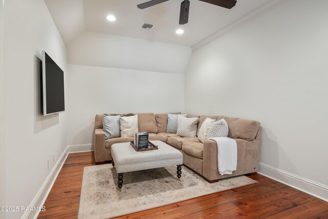 living room featuring vaulted ceiling, wood finished floors, visible vents, and baseboards