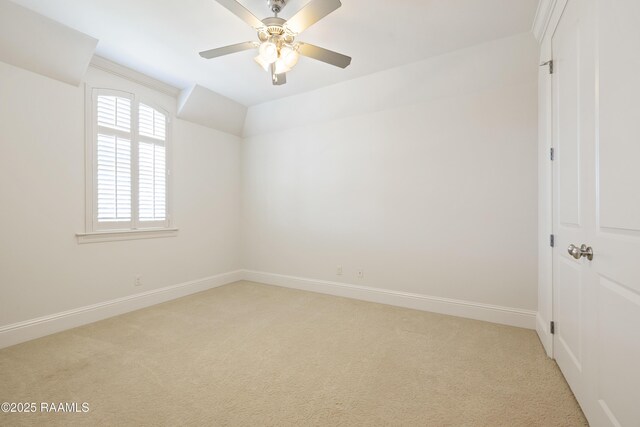 spare room with light carpet, ceiling fan, and baseboards