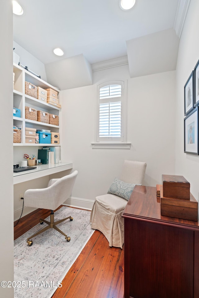 office featuring crown molding, baseboards, wood finished floors, and built in study area